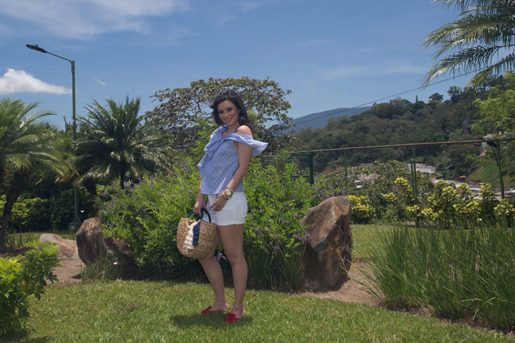 Blusa de volantes, sandalias rojas y cartera de mimbre