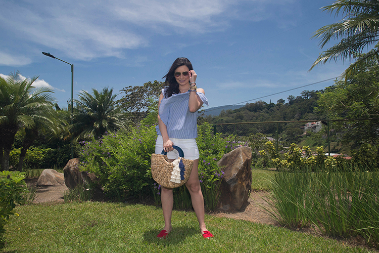 Blusa de volantes, sandalias rojas y cartera de mimbre