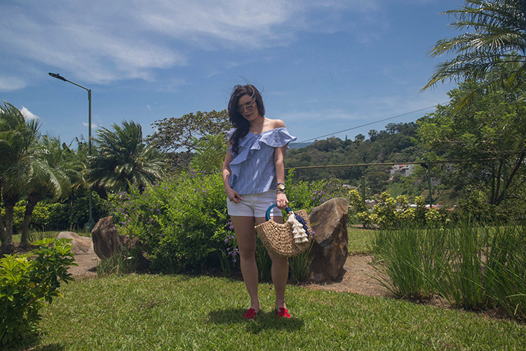 Blusa de volantes, sandalias rojas y cartera de mimbre