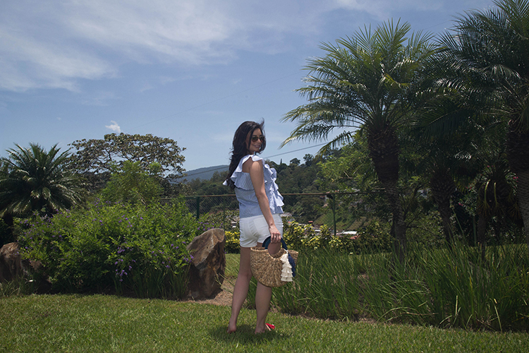 Blusa de volantes, sandalias rojas y cartera de mimbre